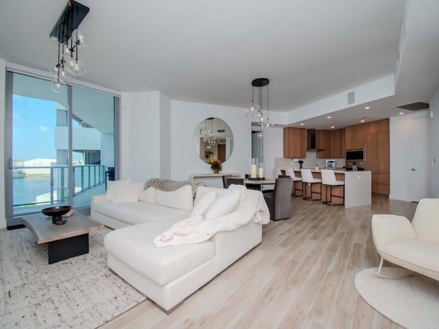 living room featuring expansive windows and light hardwood / wood-style floors