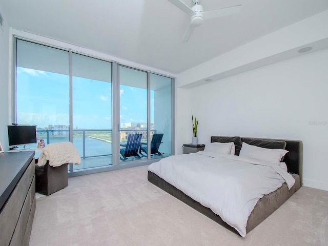 bedroom featuring light colored carpet, access to outside, a wall of windows, and ceiling fan