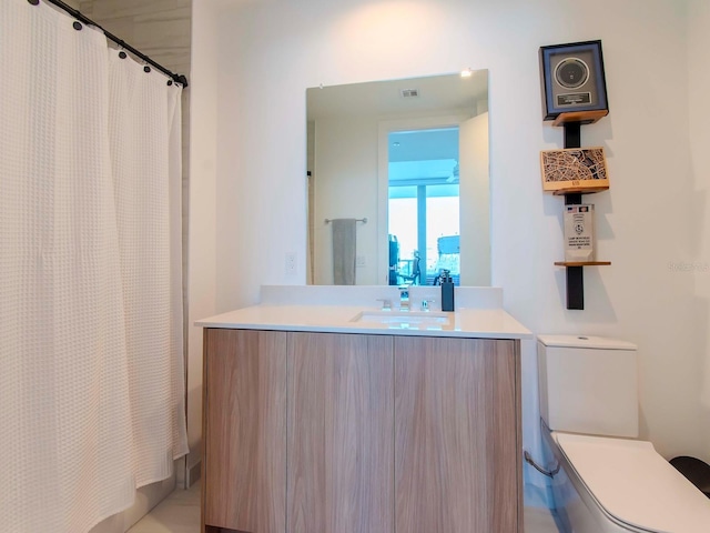 bathroom with toilet, a shower with shower curtain, and vanity