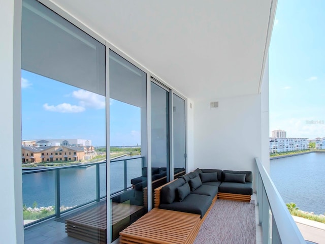 balcony featuring a water view and outdoor lounge area