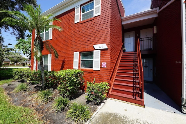 exterior space featuring brick siding and stairway