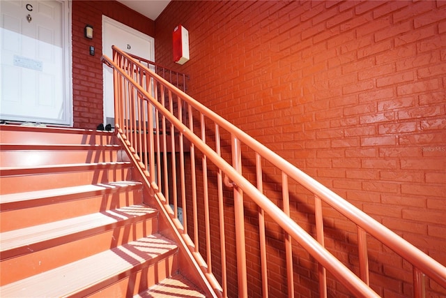 staircase with brick wall