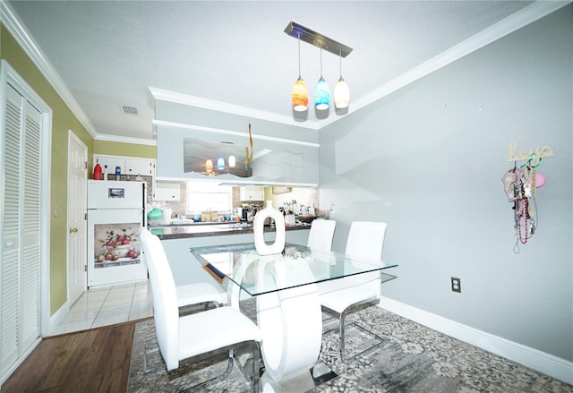 dining space with ornamental molding and wood-type flooring