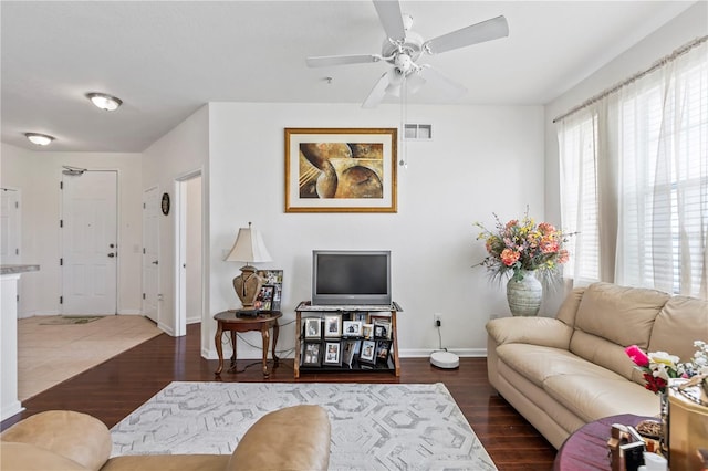 living room featuring ceiling fan and dark wood-type flooring