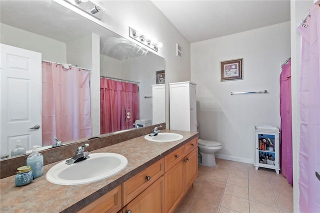 bathroom with tile patterned flooring, toilet, and vanity