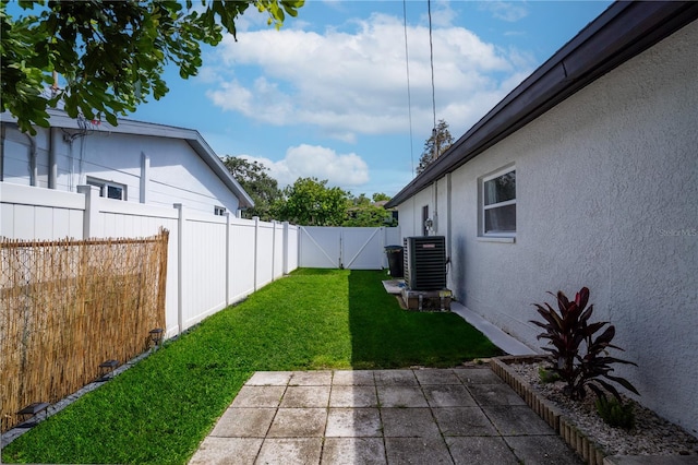 view of yard with a patio area, a gate, a fenced backyard, and central AC unit