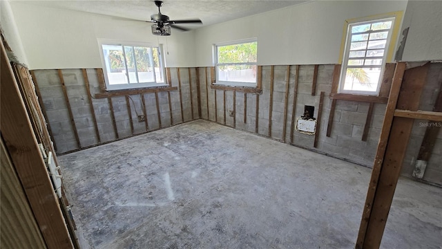 unfurnished room featuring plenty of natural light and a ceiling fan