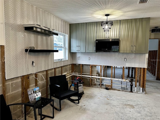 kitchen with pendant lighting, green cabinetry, and unfinished concrete flooring