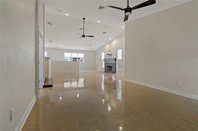 unfurnished living room with ceiling fan and high vaulted ceiling