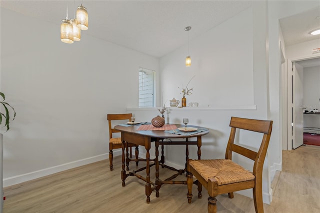 dining area with lofted ceiling and light hardwood / wood-style floors