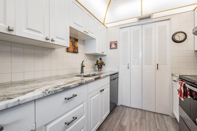 kitchen with backsplash, stainless steel appliances, light hardwood / wood-style flooring, and white cabinets