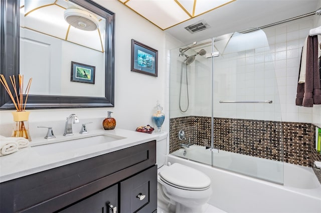 full bathroom featuring bath / shower combo with glass door, toilet, and vanity