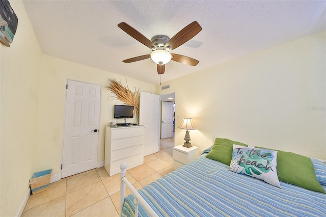 tiled bedroom featuring a textured ceiling and ceiling fan