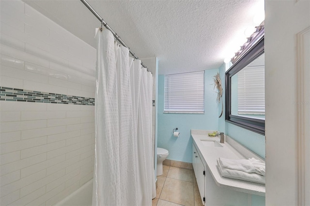 bathroom with tile patterned flooring, vanity, a textured ceiling, and toilet