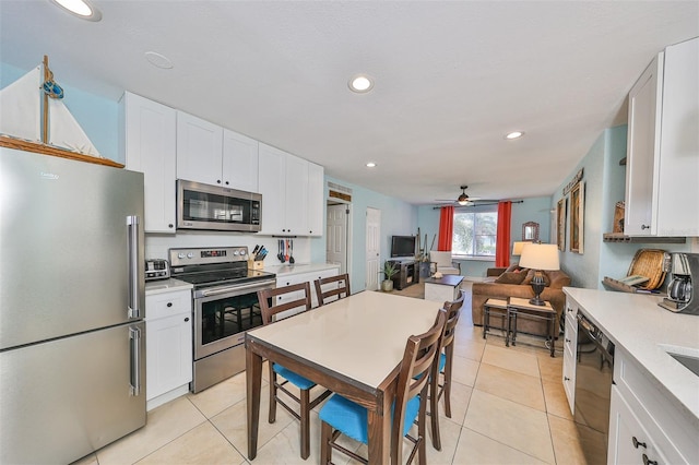 kitchen featuring white cabinets, ceiling fan, light tile patterned floors, and stainless steel appliances