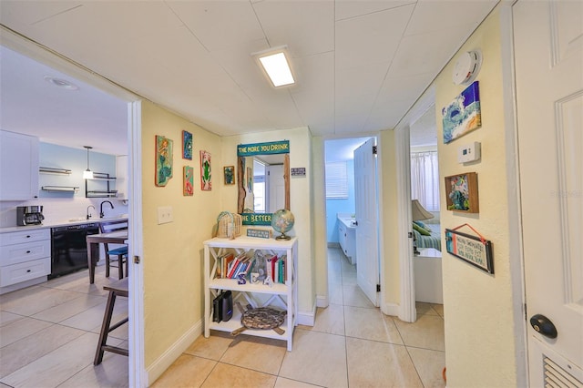 corridor with light tile patterned flooring and sink