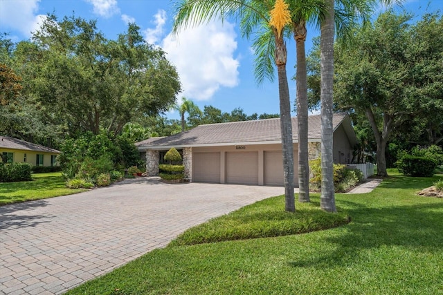 ranch-style home featuring a front lawn and a garage