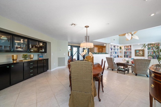 tiled dining area with ceiling fan and a textured ceiling