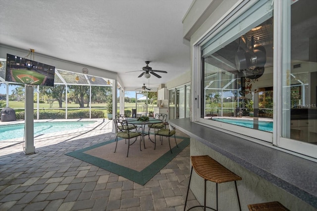 view of patio featuring glass enclosure and ceiling fan