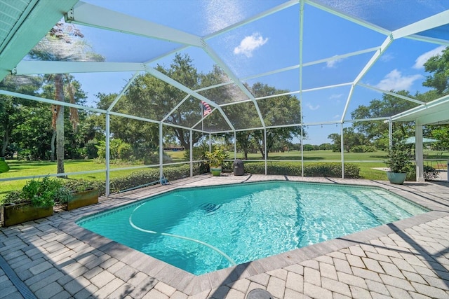 view of pool with glass enclosure and a patio