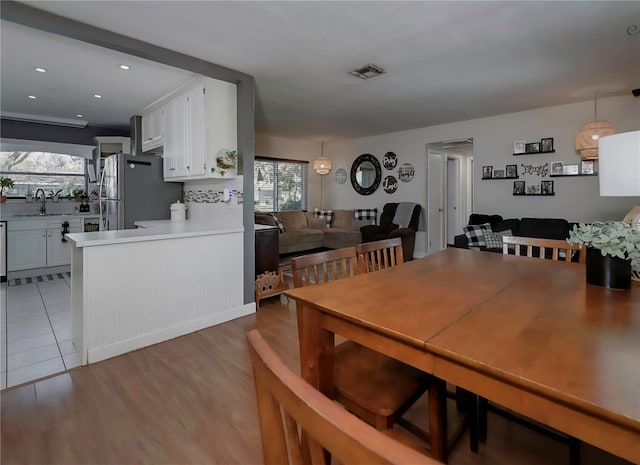 dining room featuring plenty of natural light, sink, and light hardwood / wood-style flooring