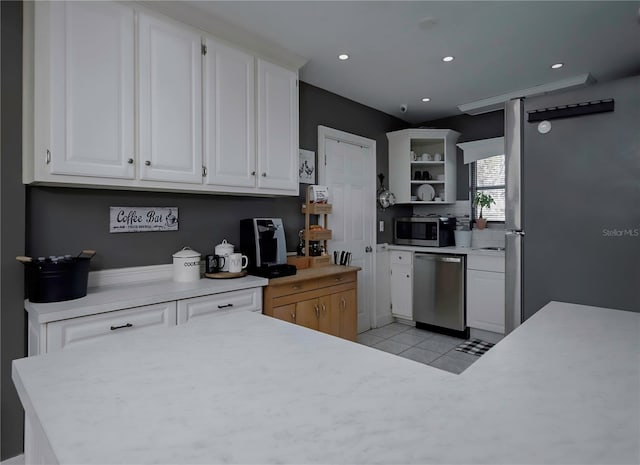 kitchen with white cabinets, appliances with stainless steel finishes, and light tile patterned floors