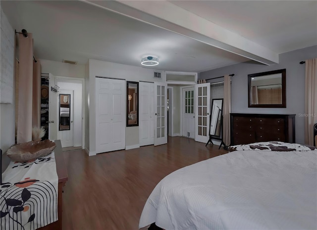 bedroom with french doors, beamed ceiling, dark hardwood / wood-style floors, and two closets