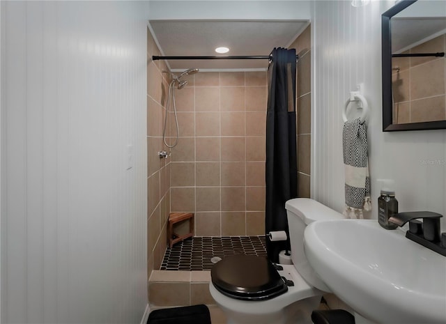 bathroom featuring toilet, sink, and curtained shower