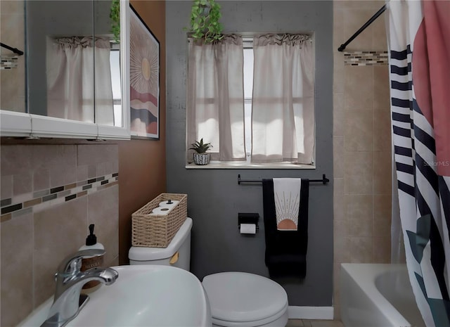 full bathroom featuring toilet, plenty of natural light, sink, and shower / bath combo with shower curtain