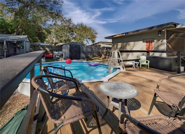 view of pool with a deck and a storage unit