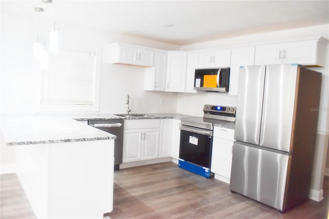 kitchen with sink, stainless steel appliances, white cabinets, and light hardwood / wood-style flooring