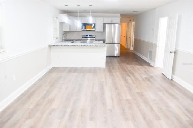 kitchen featuring light hardwood / wood-style floors, appliances with stainless steel finishes, kitchen peninsula, and white cabinetry