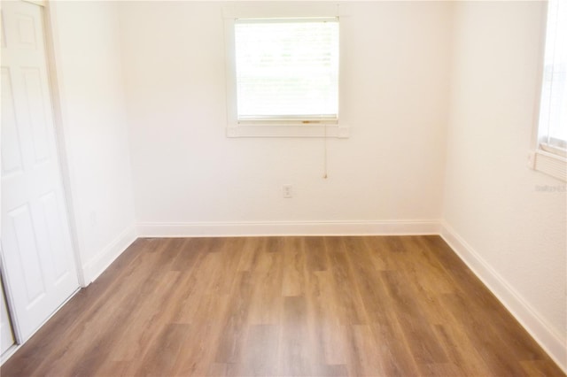 empty room with a wealth of natural light and wood-type flooring