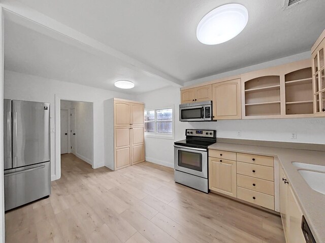 kitchen with light brown cabinetry, appliances with stainless steel finishes, and light hardwood / wood-style floors