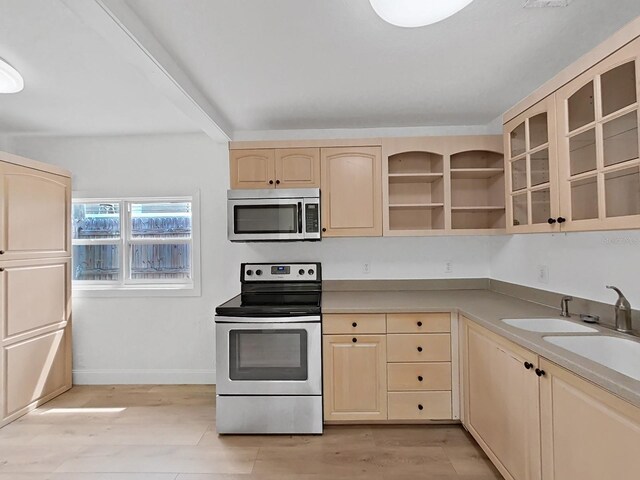 kitchen with light brown cabinetry, appliances with stainless steel finishes, and light hardwood / wood-style floors