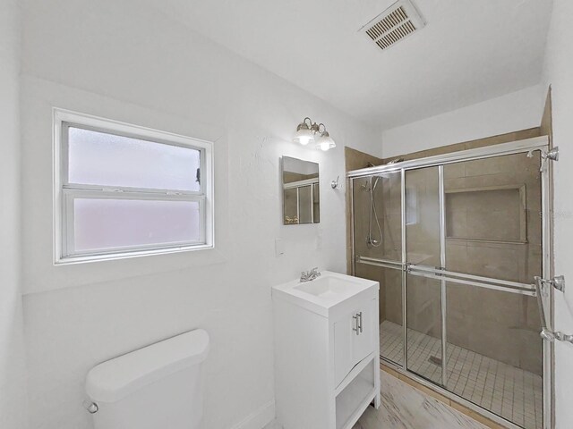 bathroom with toilet, vanity, and walk in shower