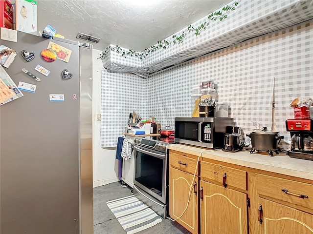 kitchen featuring stainless steel appliances and concrete flooring