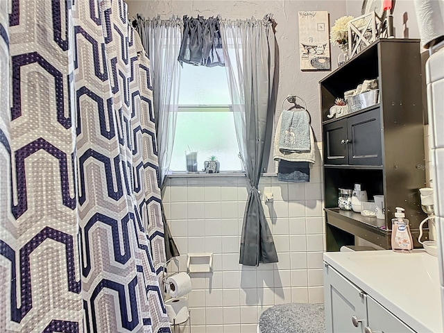 bathroom featuring tile walls and vanity