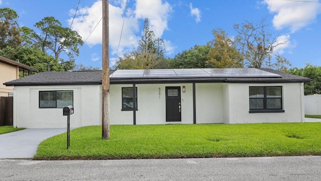 single story home with solar panels and a front yard