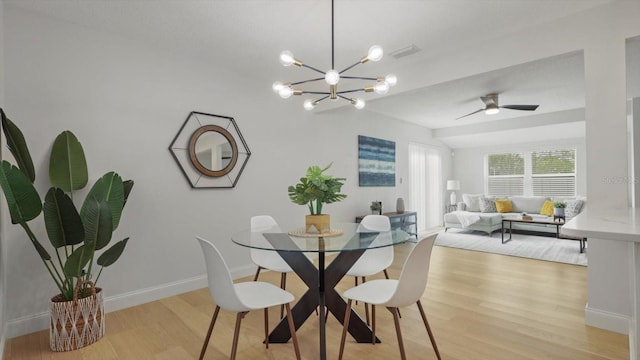 dining area featuring ceiling fan with notable chandelier and light wood-type flooring