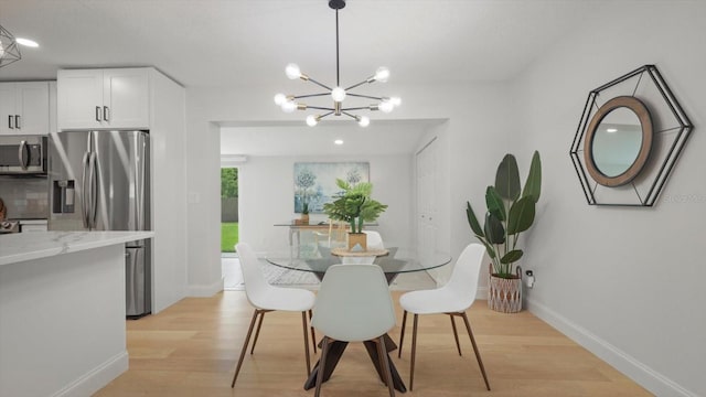 dining space featuring light hardwood / wood-style floors and a chandelier