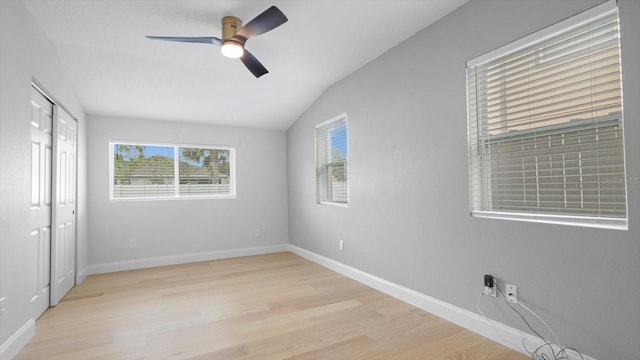 unfurnished bedroom with ceiling fan, light wood-type flooring, and vaulted ceiling