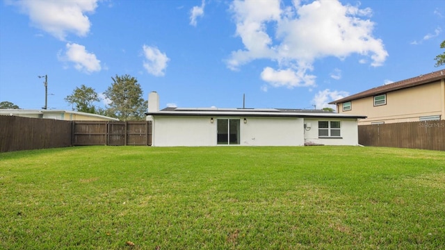 rear view of house featuring a lawn