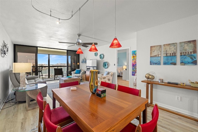 dining room featuring a textured ceiling, ceiling fan, light hardwood / wood-style floors, and track lighting