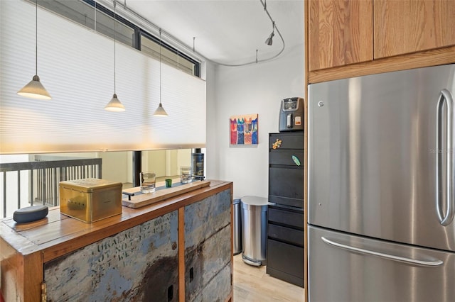 kitchen with hanging light fixtures, light wood finished floors, and freestanding refrigerator