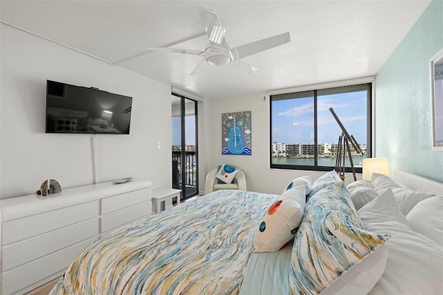 bedroom featuring access to outside, a textured ceiling, and a ceiling fan