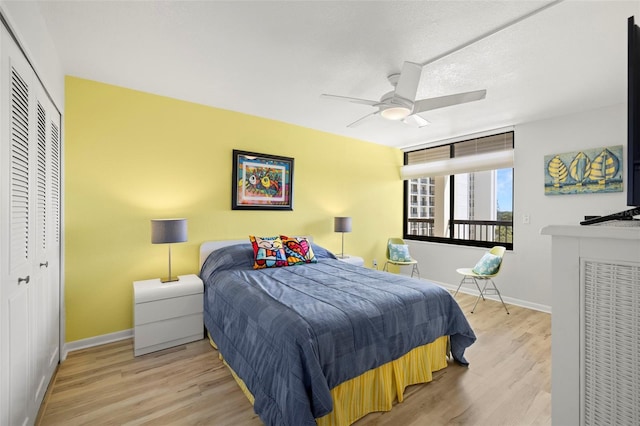 bedroom featuring light hardwood / wood-style floors, ceiling fan, and a closet