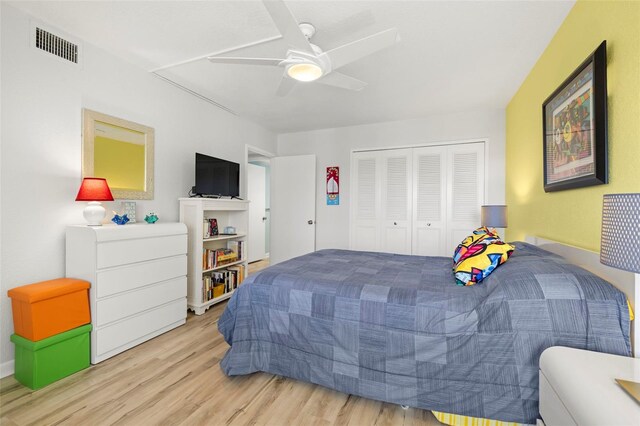 bedroom with light hardwood / wood-style flooring, ceiling fan, and a closet