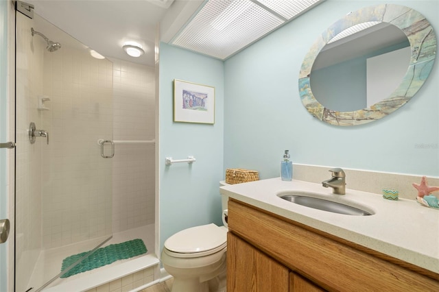 full bathroom with vanity, a shower stall, and toilet