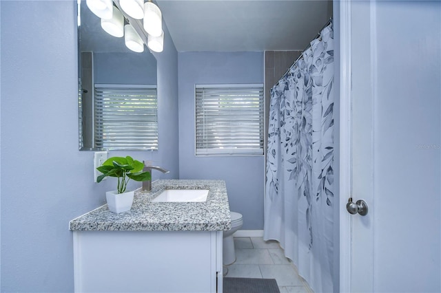 bathroom featuring tile patterned flooring, toilet, a shower with shower curtain, and vanity